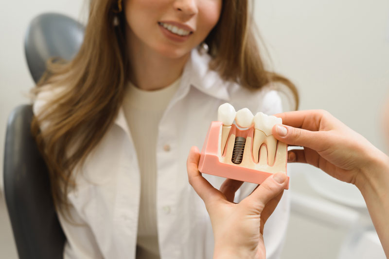 Dental Patient Getting Shown A Dental Implant Model During Her Consultation in Fort Worth, TX